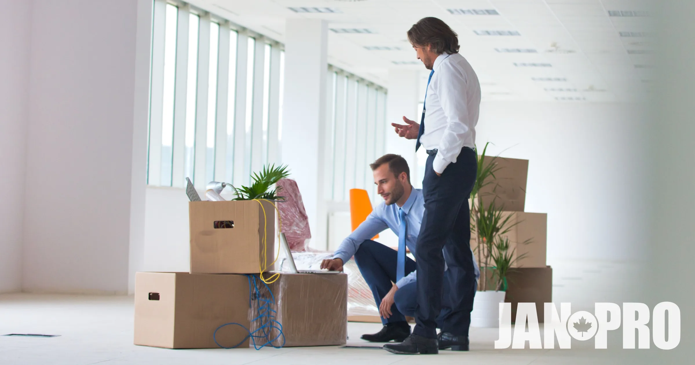 2 individuals in an office with moving boxes