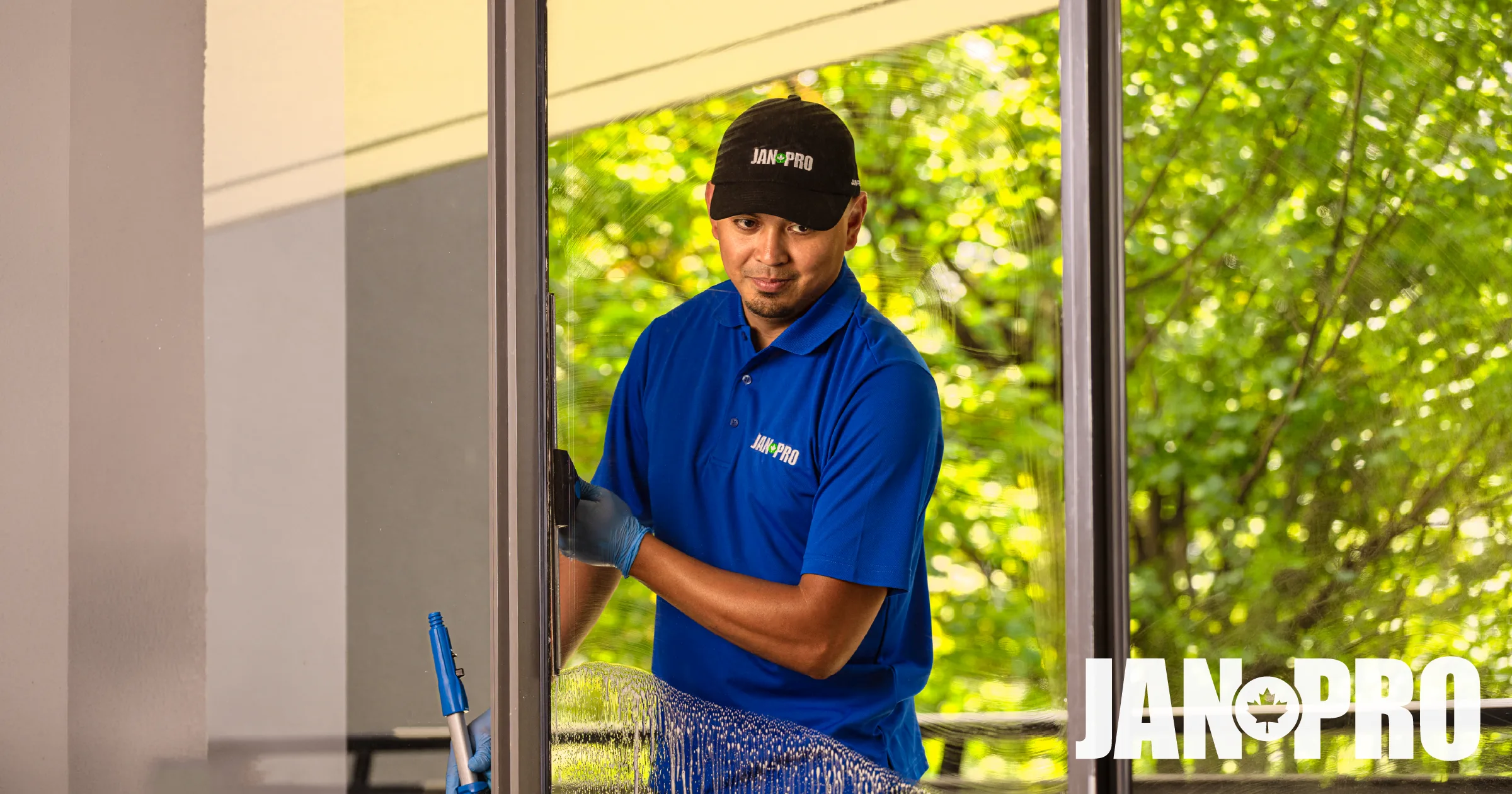 A JAN-PRO Certified Business Owner squeegeeing a window